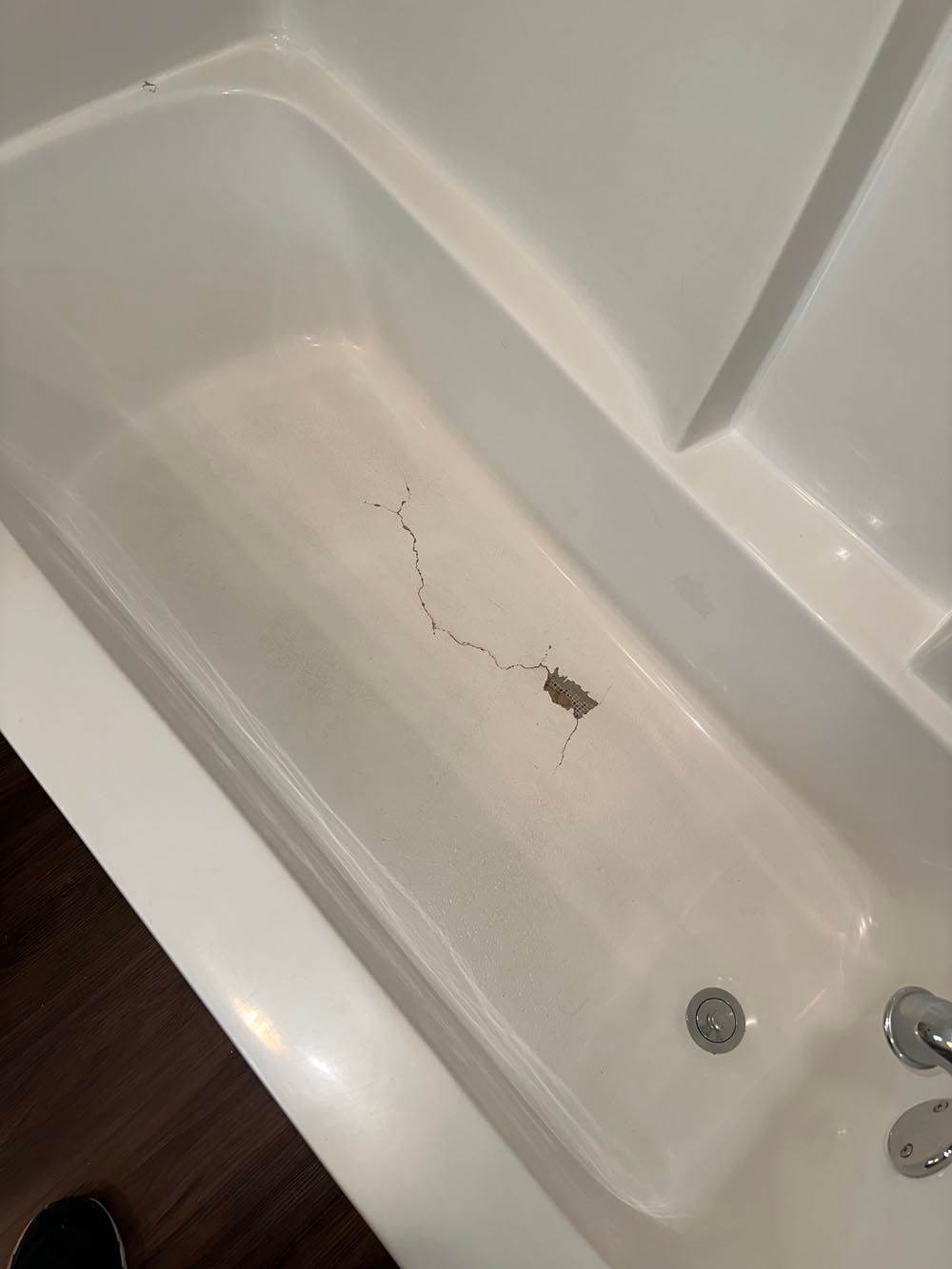 White bathtub with dark line and debris at bottom.