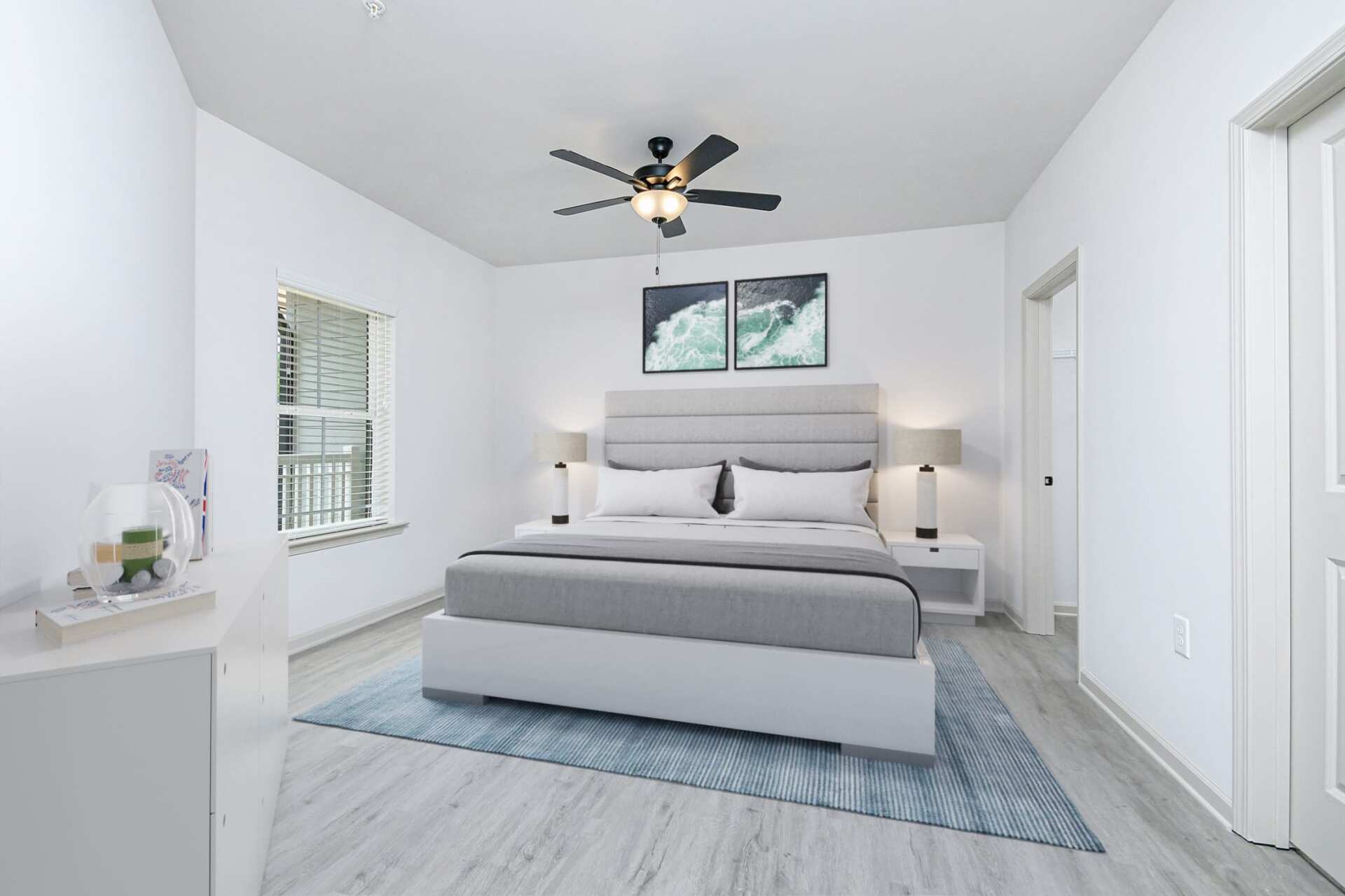 The Blakely bedroom with bed, rug, ceiling fan, and wall art.