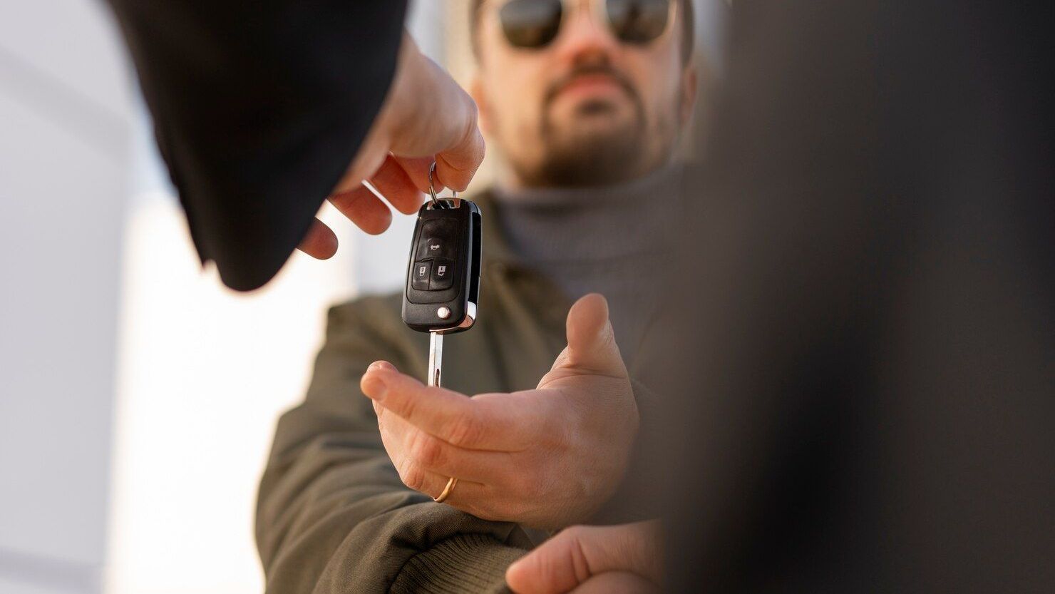 A person is using a screwdriver to open a car door lock.