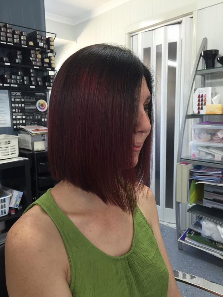 A Woman With Red Hair is Wearing a Green Tank Top — Rayzr Hair Artistry in Eli Waters, QLD