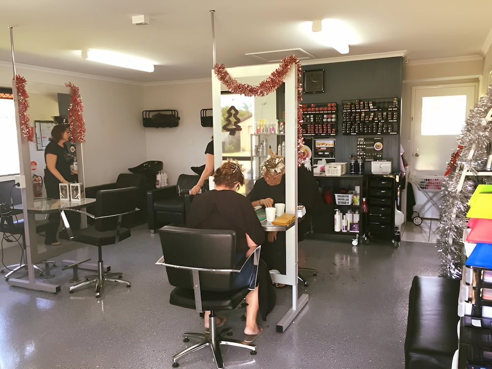 A Woman is Getting Her Hair Cut in a Salon — Rayzr Hair Artistry in Eli Waters, QLD