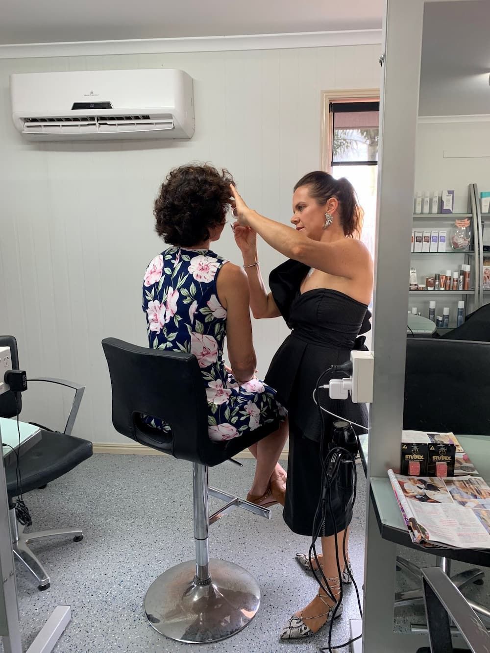 A Woman is Sitting in a Chair Getting Her Hair Done in a Salon — Rayzr Hair Artistry in Hervey Bay, QLD