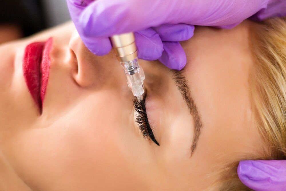 A Woman is Getting Permanent Makeup on Her Eyebrows — Rayzr Hair Artistry in Eli Waters, QLD