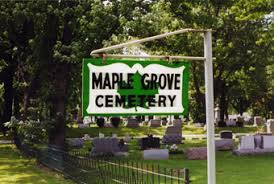 A green and white sign for maple grove cemetery