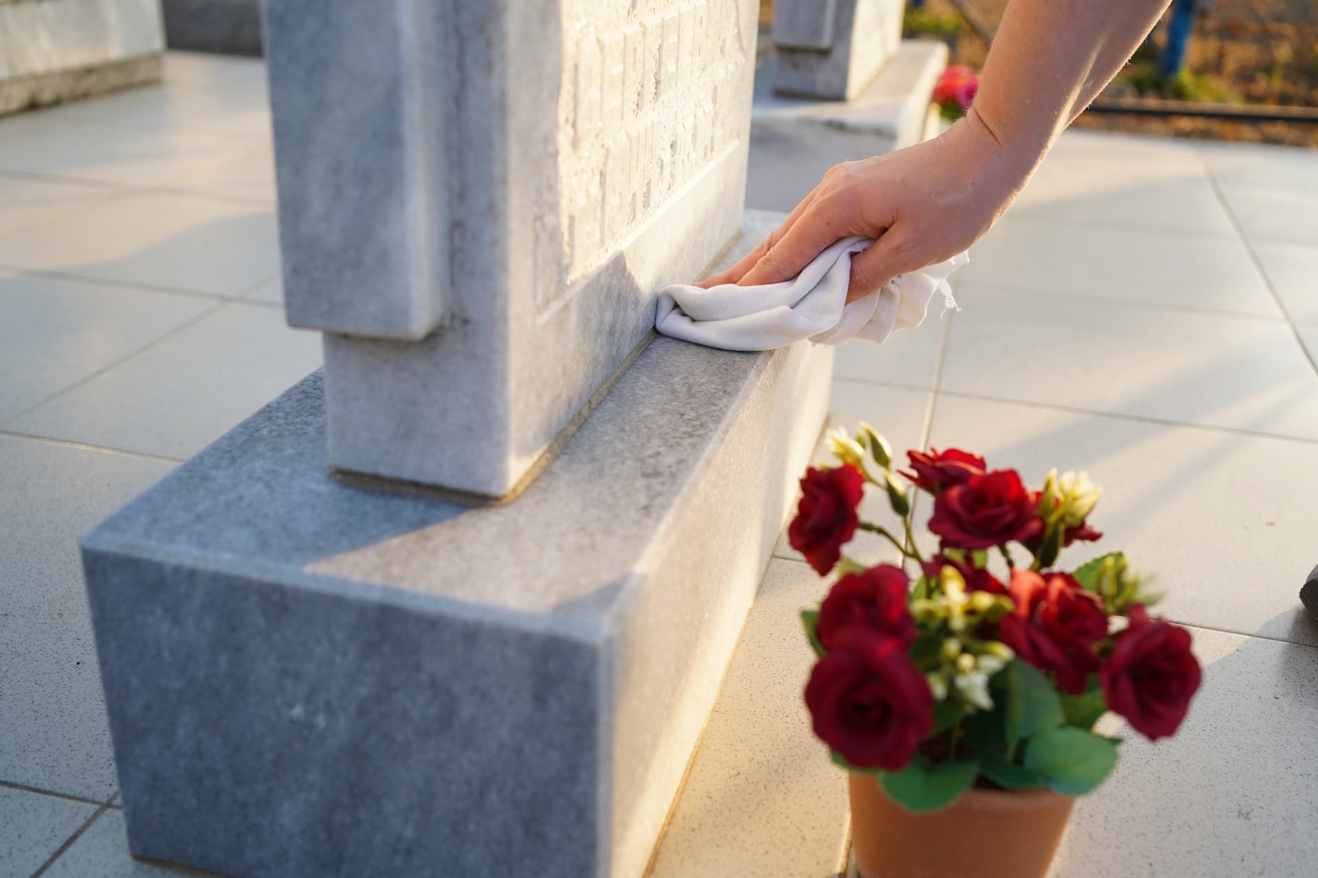 A person is cleaning a grave with a towel.