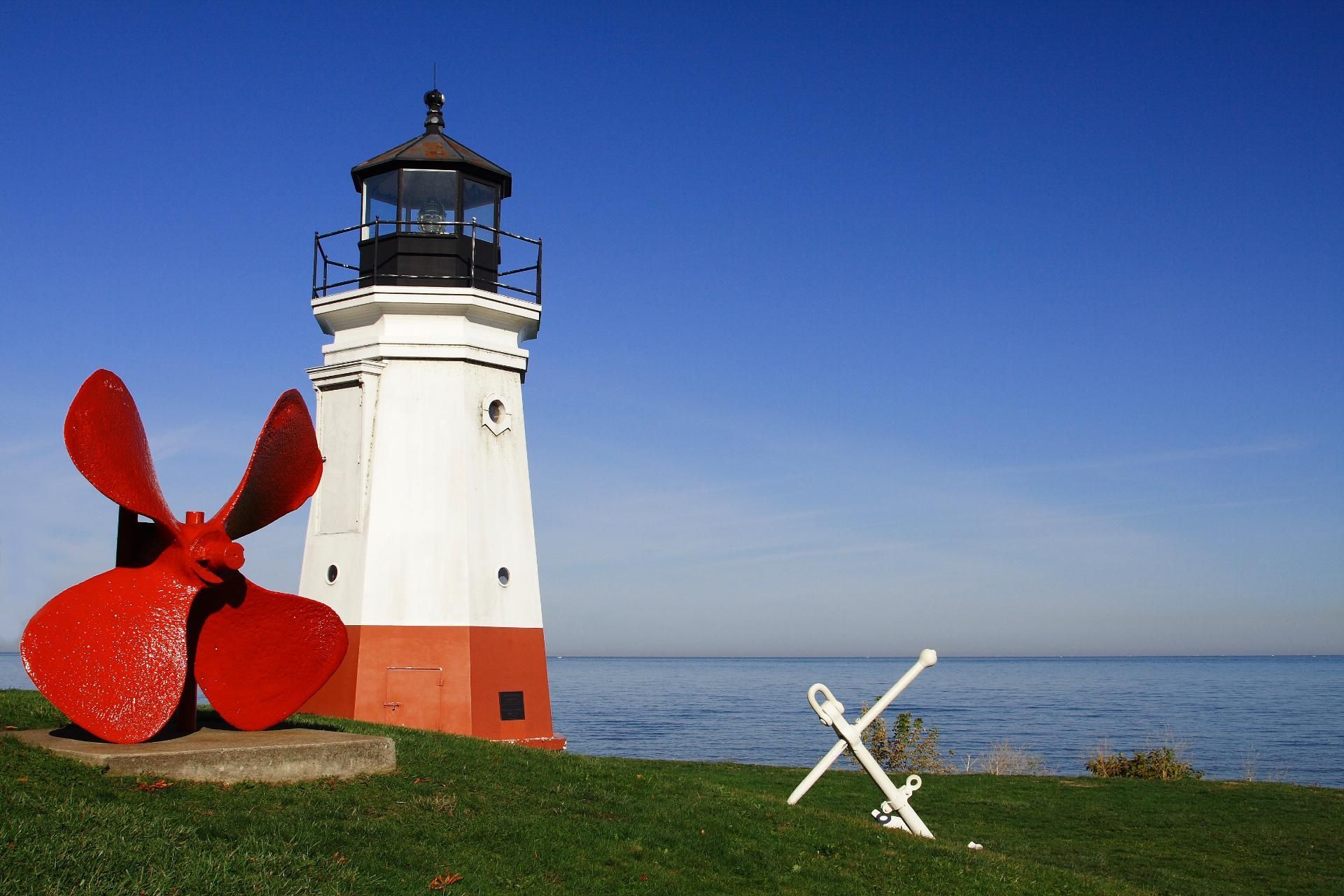 A lighthouse with a red propeller in front of it