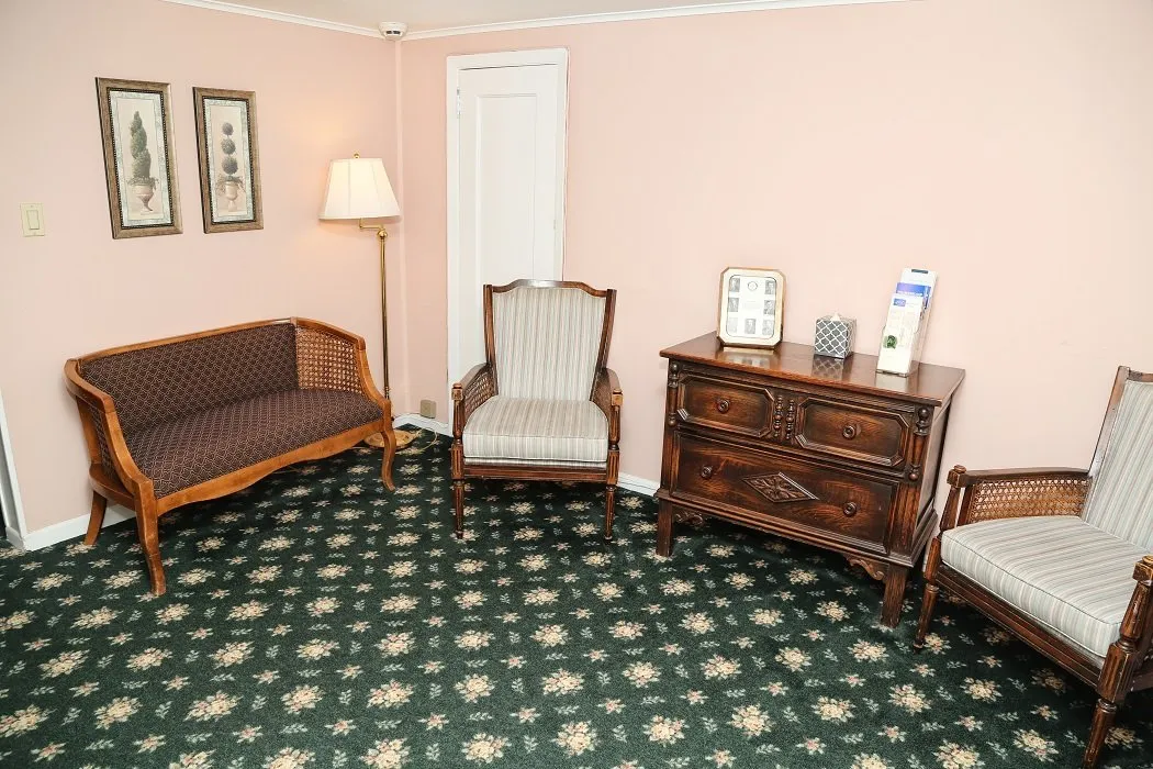 funeral room lounge area brown sofa and white chairs