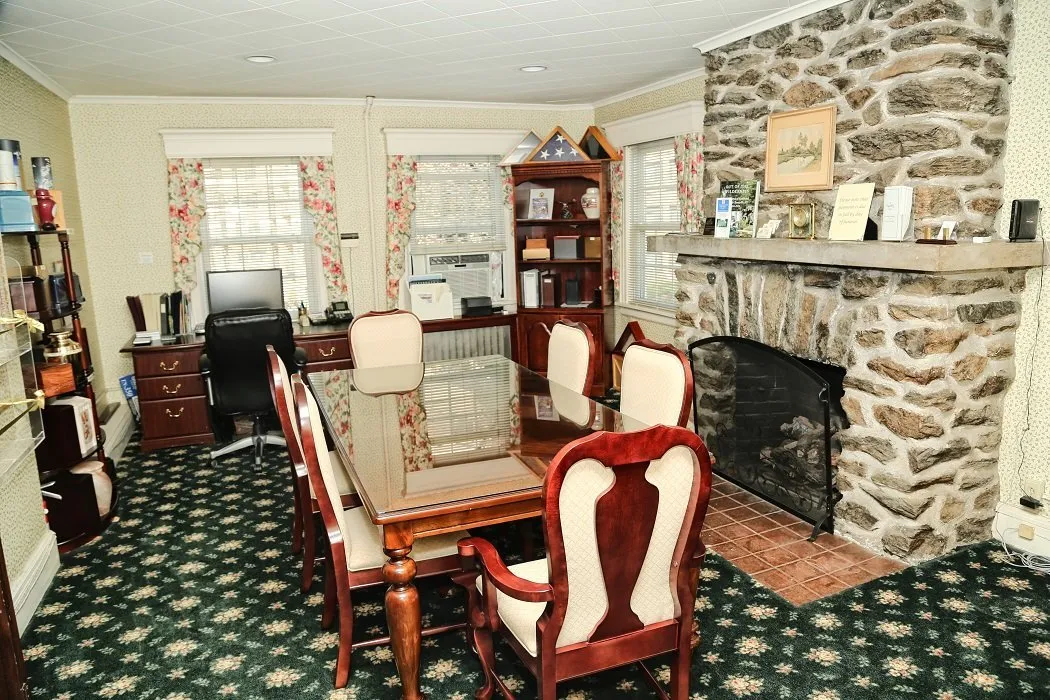funeral home facilities room with large table and fireplace