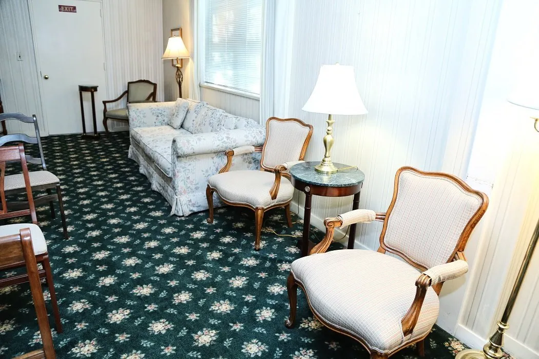 funeral home facilities room with large white sofa and two white chairs