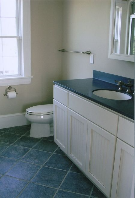 A bathroom with a toilet a sink and a window