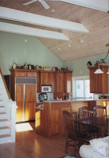 A kitchen with wooden cabinets and a ceiling fan