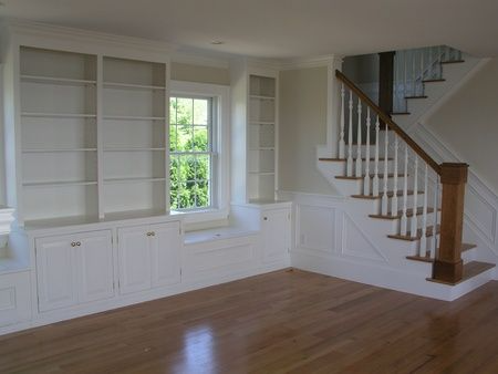 An empty living room with stairs and shelves