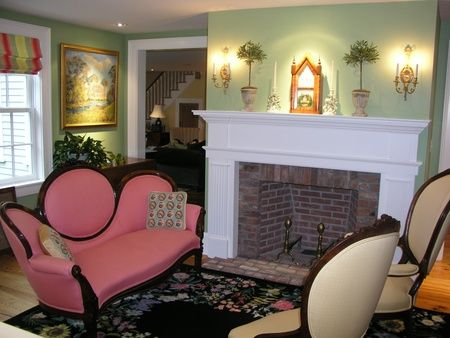 A living room with a pink couch and a fireplace