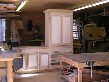 A woodworking shop with cabinets and a workbench