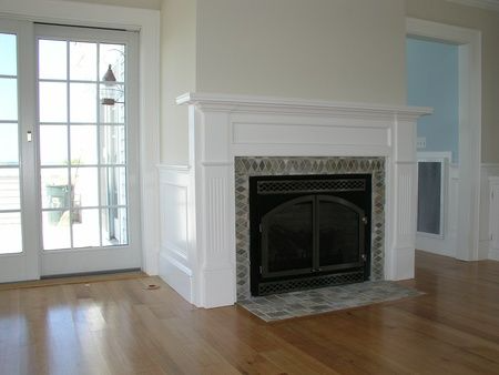 An empty living room with a fireplace and sliding glass doors
