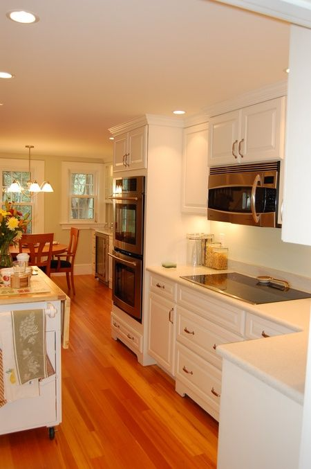 A kitchen with white cabinets and a stove top oven
