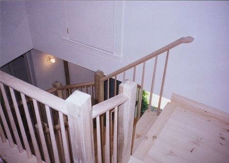 A wooden staircase with a white railing and a wooden floor