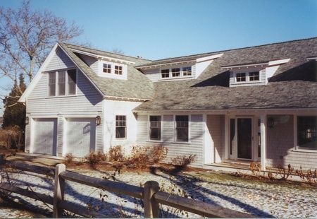 A white house with a wooden fence in front of it