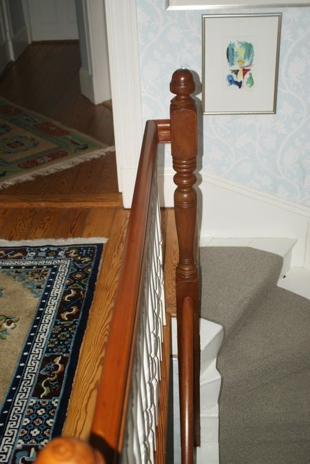 A wooden railing with a picture on the wall above it