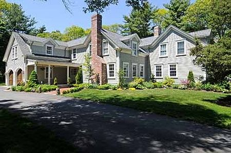 A large house with a lot of windows and a driveway in front of it.