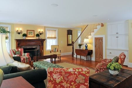 A living room with a fireplace and stairs in the background