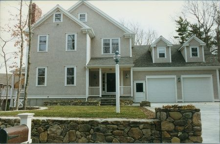 A large house with a stone wall in front of it