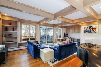 A living room with a blue couch and a piano.