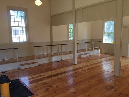 A large empty room with wooden floors and white walls.