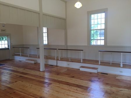An empty room with wooden floors and white walls