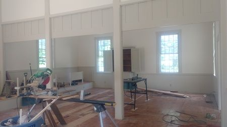 A room with a lot of windows and a table with a saw in it.