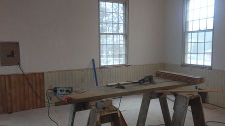 A room with a wooden table and a saw in it.