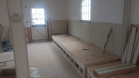 A room with a bench and a window in it.