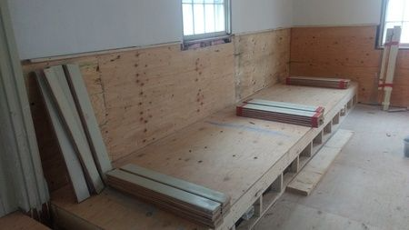 A wooden couch is being built in a room.