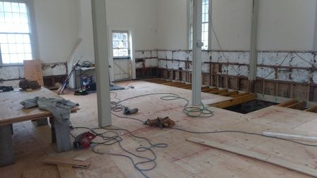 A room with a wooden floor and a lot of wires hanging from the ceiling.