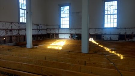 The sun is shining through the windows of an empty church.