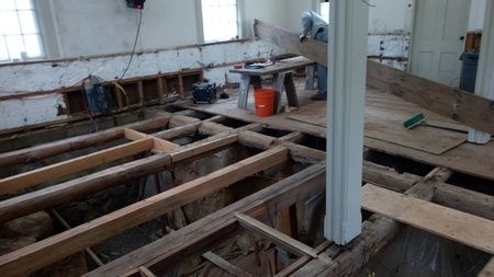 A man is working on the floor of a building.