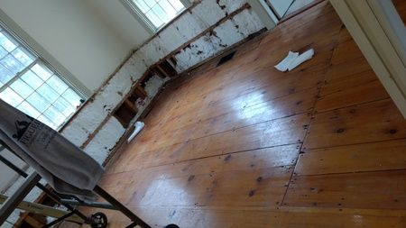 A room with a wooden floor and white cabinets.