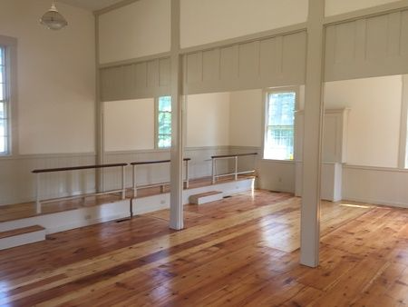 A large empty room with wooden floors and white walls.