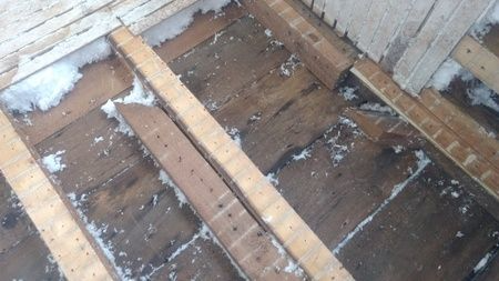 A close up of a wooden floor with snow on it.