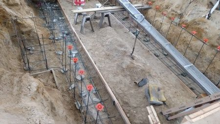 A concrete wall is being built in a hole in the ground.