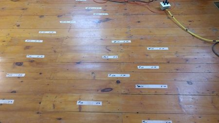 A wooden floor with a bunch of stickers on it.