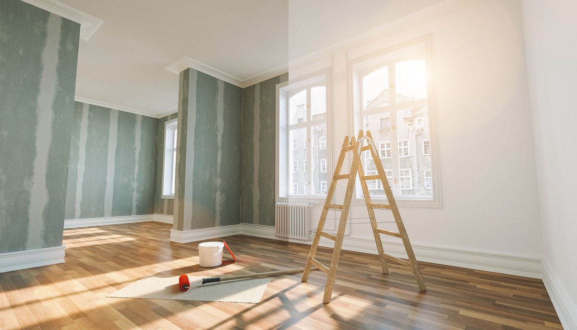 An empty room with a ladder in the middle of it.