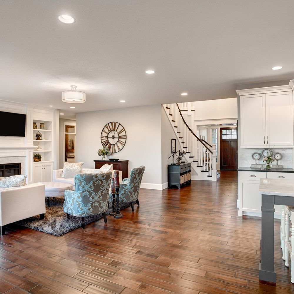A living room with hardwood floors and a clock on the wall.