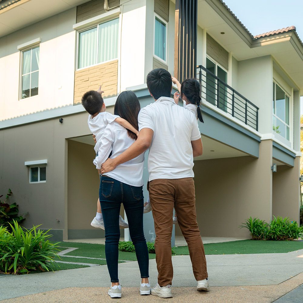 A family is standing in front of a large house.