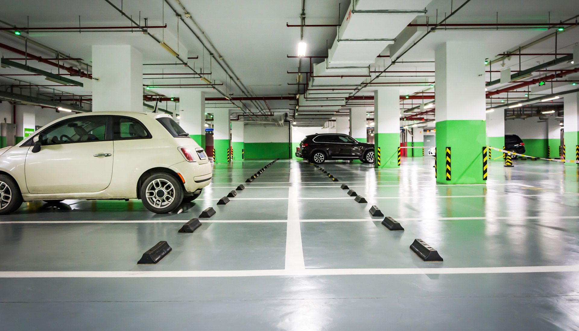 A white car is parked in a parking garage.
