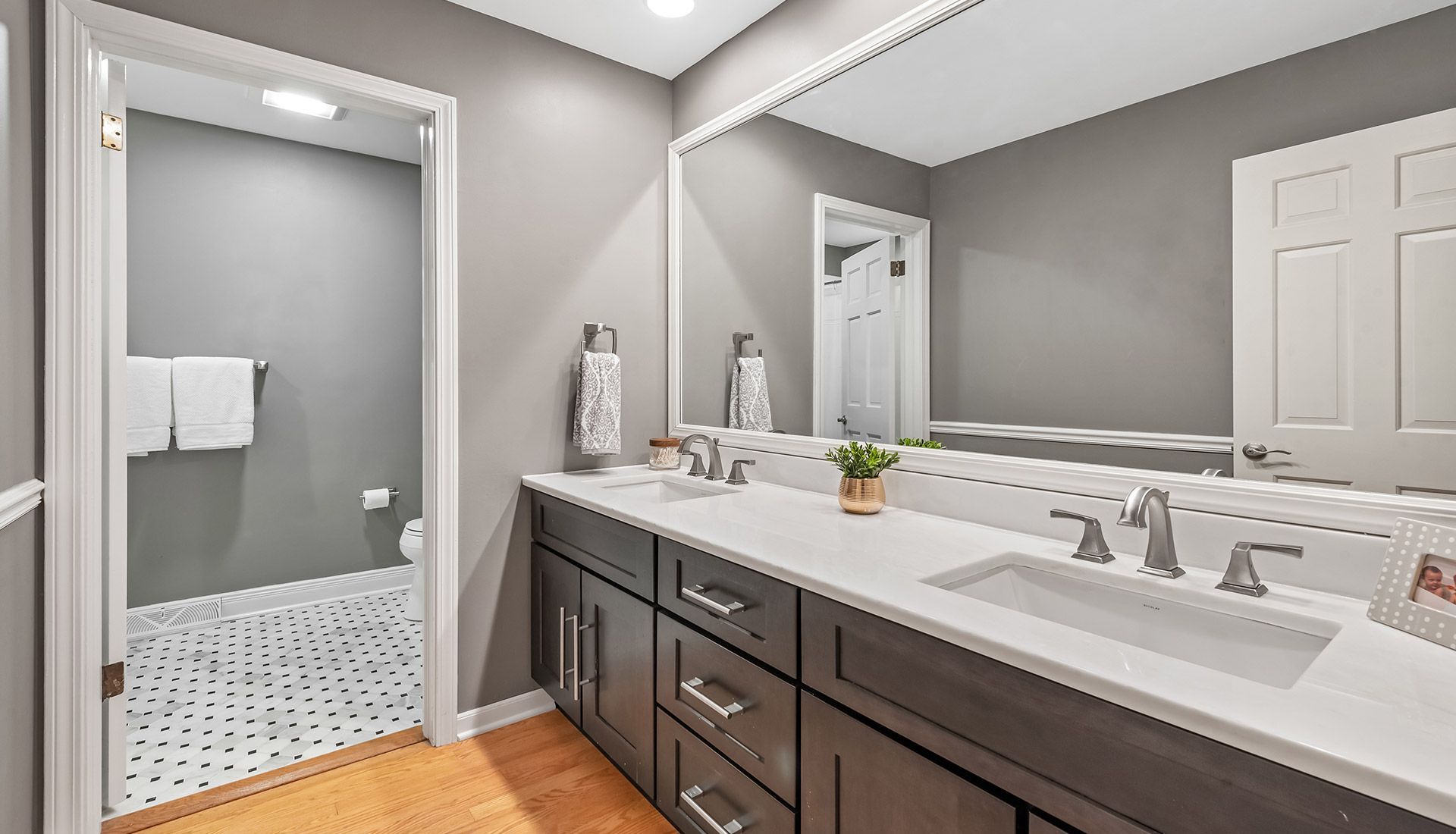 A bathroom with two sinks and a large mirror.