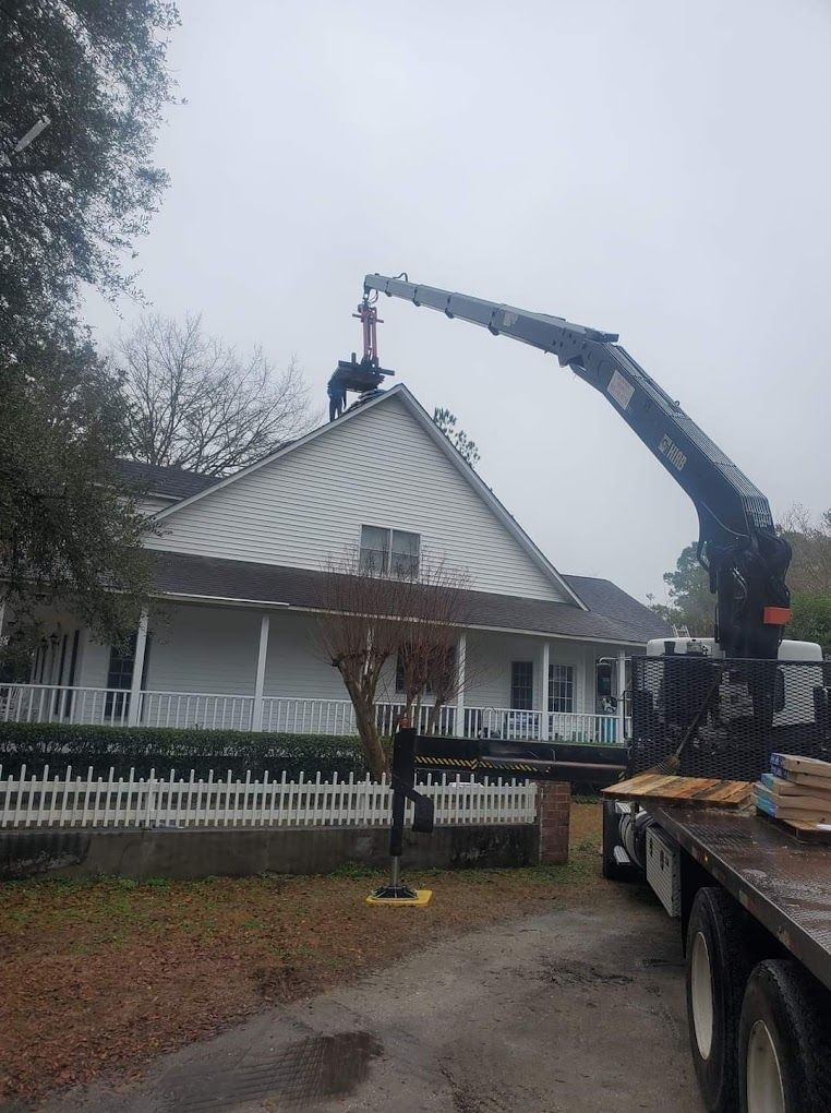 A crane is working on the roof of a house