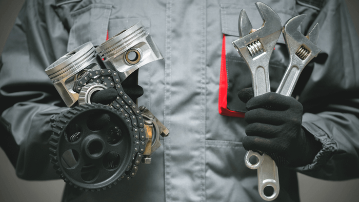 two mechanics performing service on a car