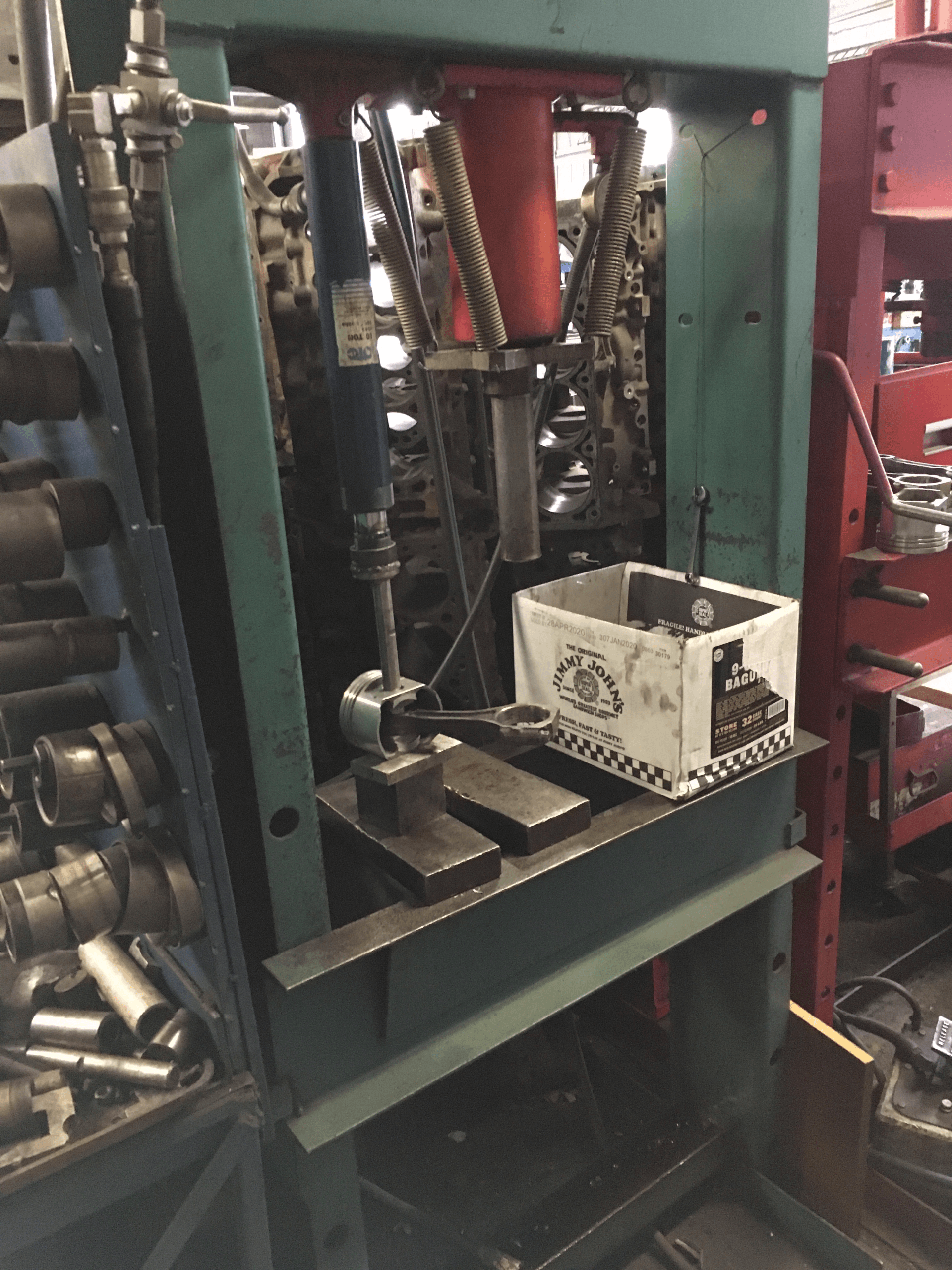 Green industrial press with tools and parts.