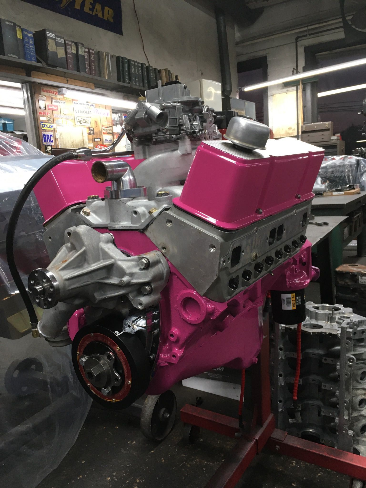 Pink engine on a stand, in a workshop setting.